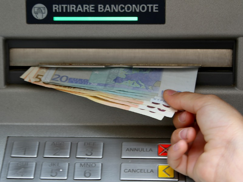 Withdraw money in banknotes from an ATM in Italy stock photo