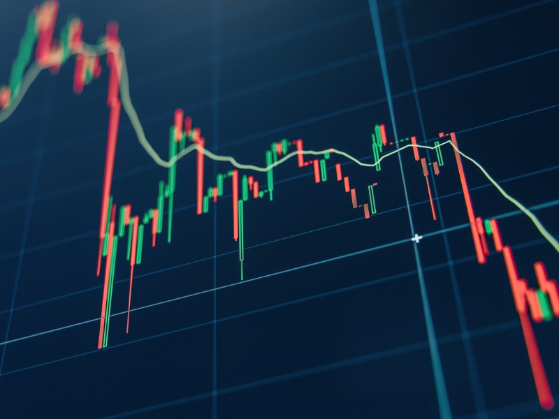 Green and red trading candlesticks on blue display