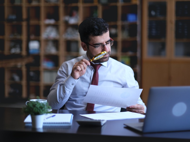 Businessman examines statistics on a page