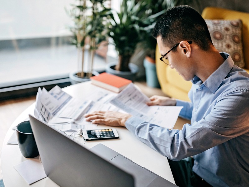 Man calculating financial bills at home