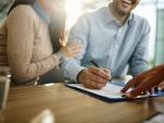 Couple signing a contract in the office